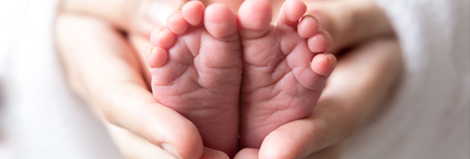 Hænder der holder om babyfødder